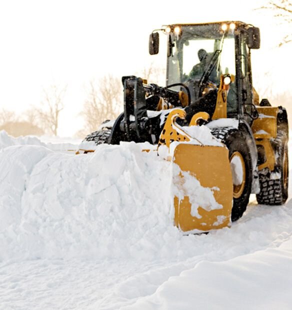 Large Yellow tractor removing large amounts of snow